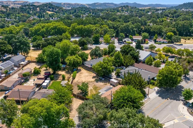 an aerial view of residential houses with outdoor space and trees