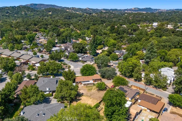 an aerial view of residential houses with outdoor space and trees