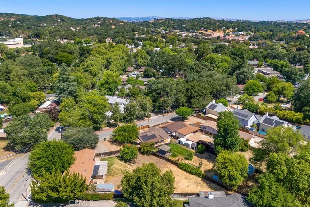 an aerial view of residential houses with outdoor space and trees