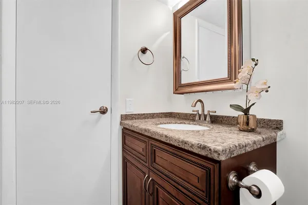 a bathroom with a granite countertop sink and a mirror
