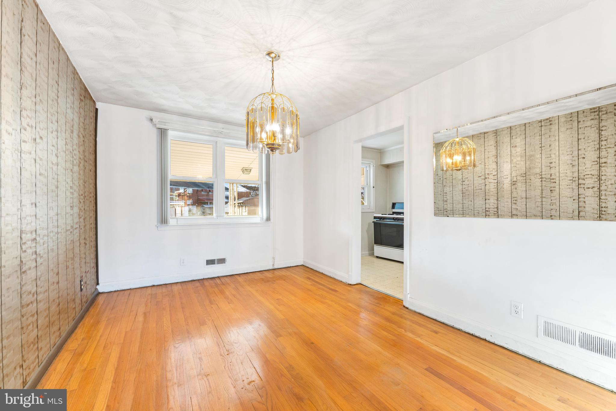 2245 Searles Road Baltimore, MD 21222 - Photo 12 of 33 a view of empty room with wooden floor and kitchen view