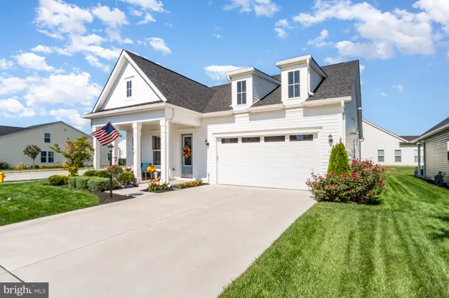 a front view of a house with a yard and outdoor seating