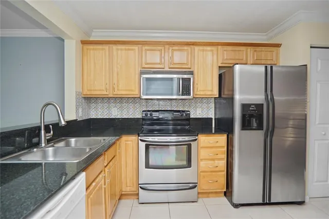a kitchen with stainless steel appliances granite countertop a stove a refrigerator and a sink
