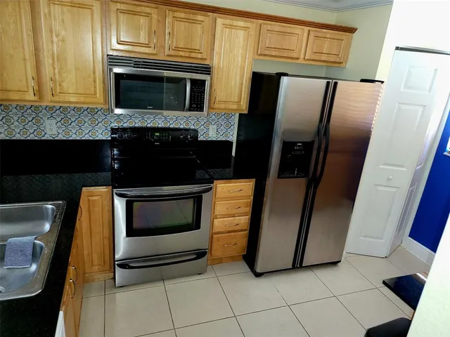a kitchen with granite countertop a refrigerator and a stove