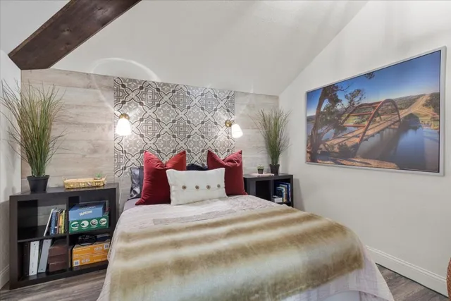 a bedroom with a bed and a painting on the wall