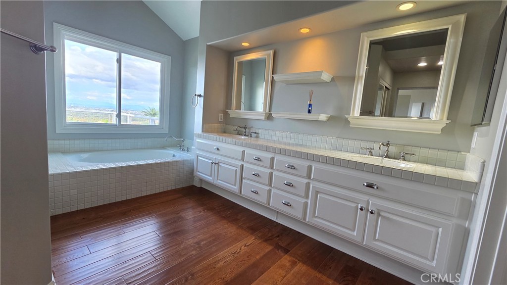 8 Miranda Irvine, CA 92603 - Photo 21 of 32 a bathroom with a granite countertop sink a large mirror a bathtub and window