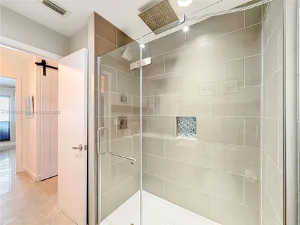 a bathroom with a shower and a glass door