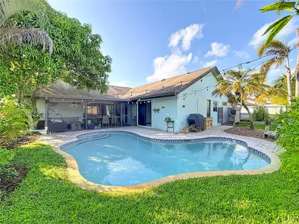 a view of a house with swimming pool and sitting area