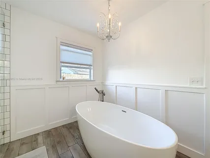 a white bath tub sitting in a bathroom next to a window