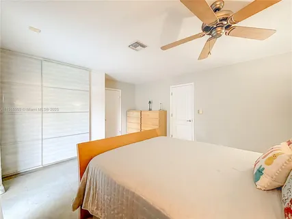 a bedroom with a bed and a ceiling fan