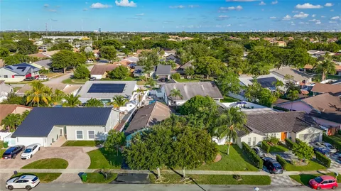 an aerial view of residential houses with outdoor space and swimming pool