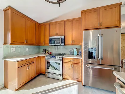 a kitchen with stainless steel appliances granite countertop a refrigerator a stove top oven a sink and dishwasher