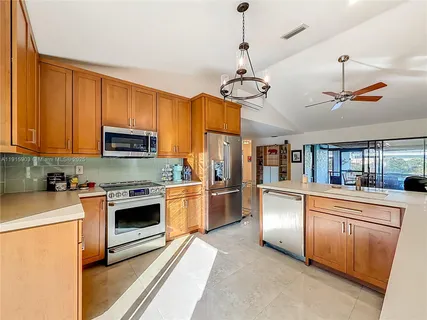 a large kitchen with stainless steel appliances granite countertop a stove oven and a refrigerator
