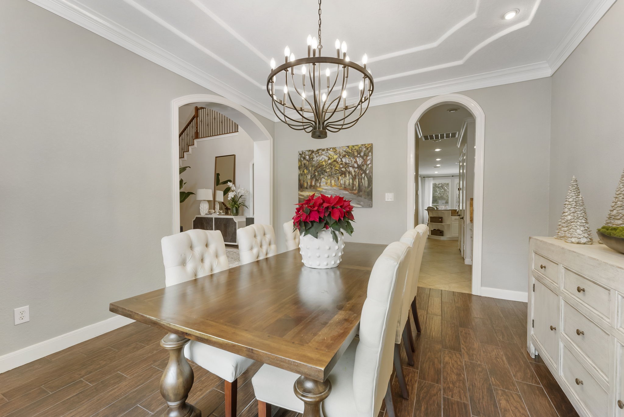 6 Lagato Place Spring, TX 77382 - Photo 11 of 42 The dining room features architectural ceiling detail and an elegant chandelier, making it ideal for hosting dinners and celebrations. Arched openings connect the space gracefully to the rest of the home.