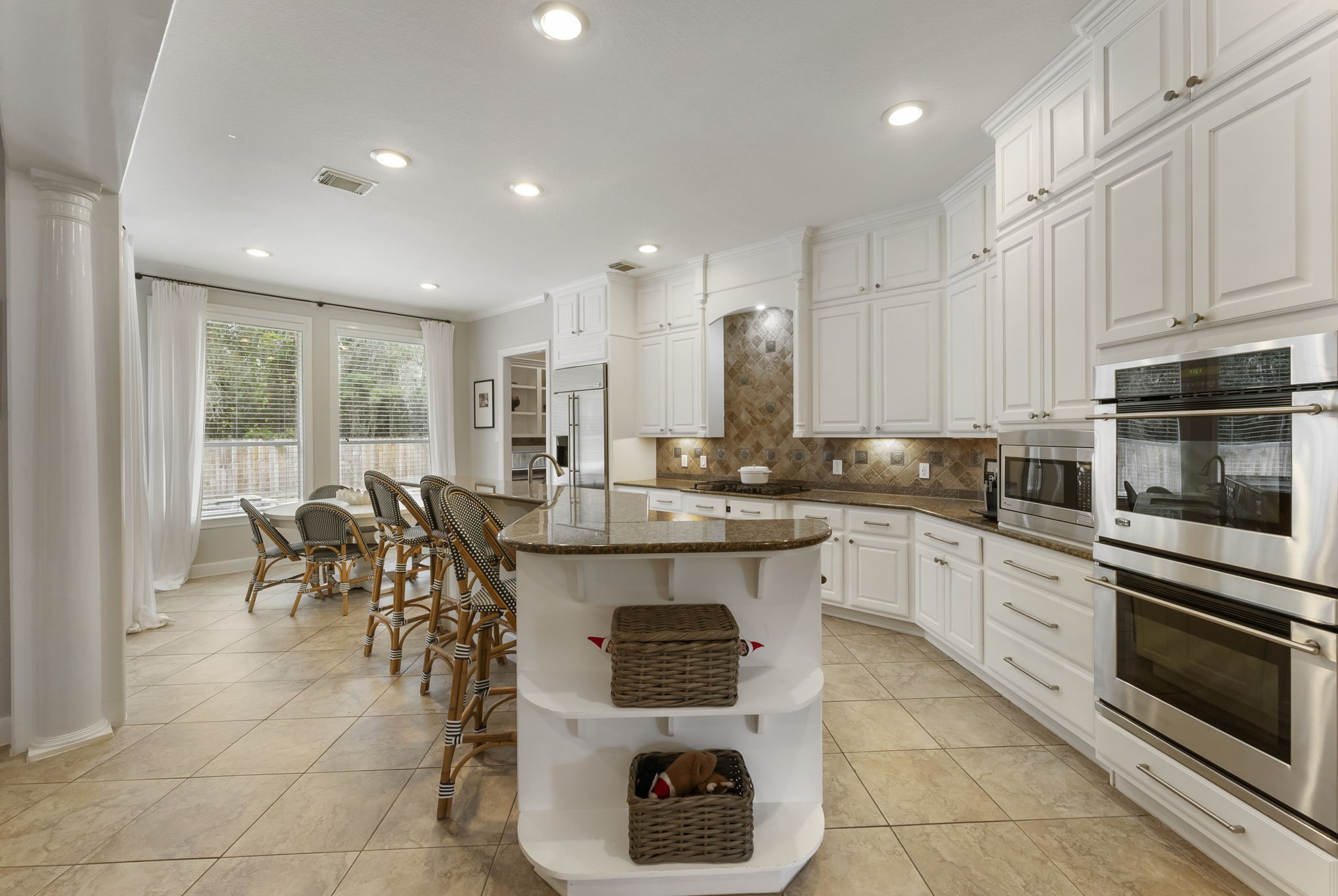 6 Lagato Place Spring, TX 77382 - Photo 12 of 42 The kitchen is designed for both daily use and hosting, with expansive counters and abundant cabinetry expanded to the ceiling with soft closing drawers and doors. Open sightlines keep the space connected to the main living areas.