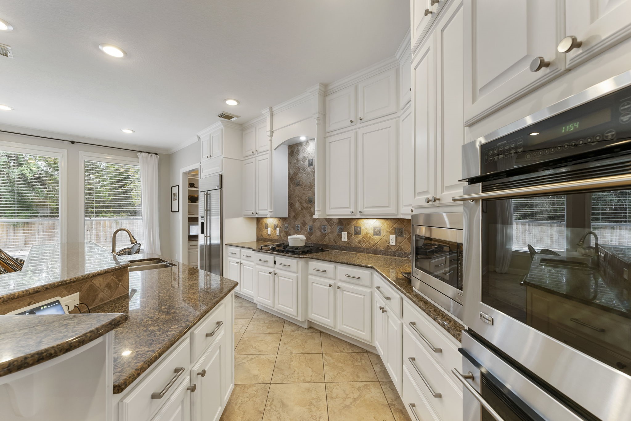 6 Lagato Place Spring, TX 77382 - Photo 13 of 42 An oversized island anchors the kitchen, providing seating and workspace for gathering. The adjacent breakfast area is filled with natural light and overlooks the backyard.