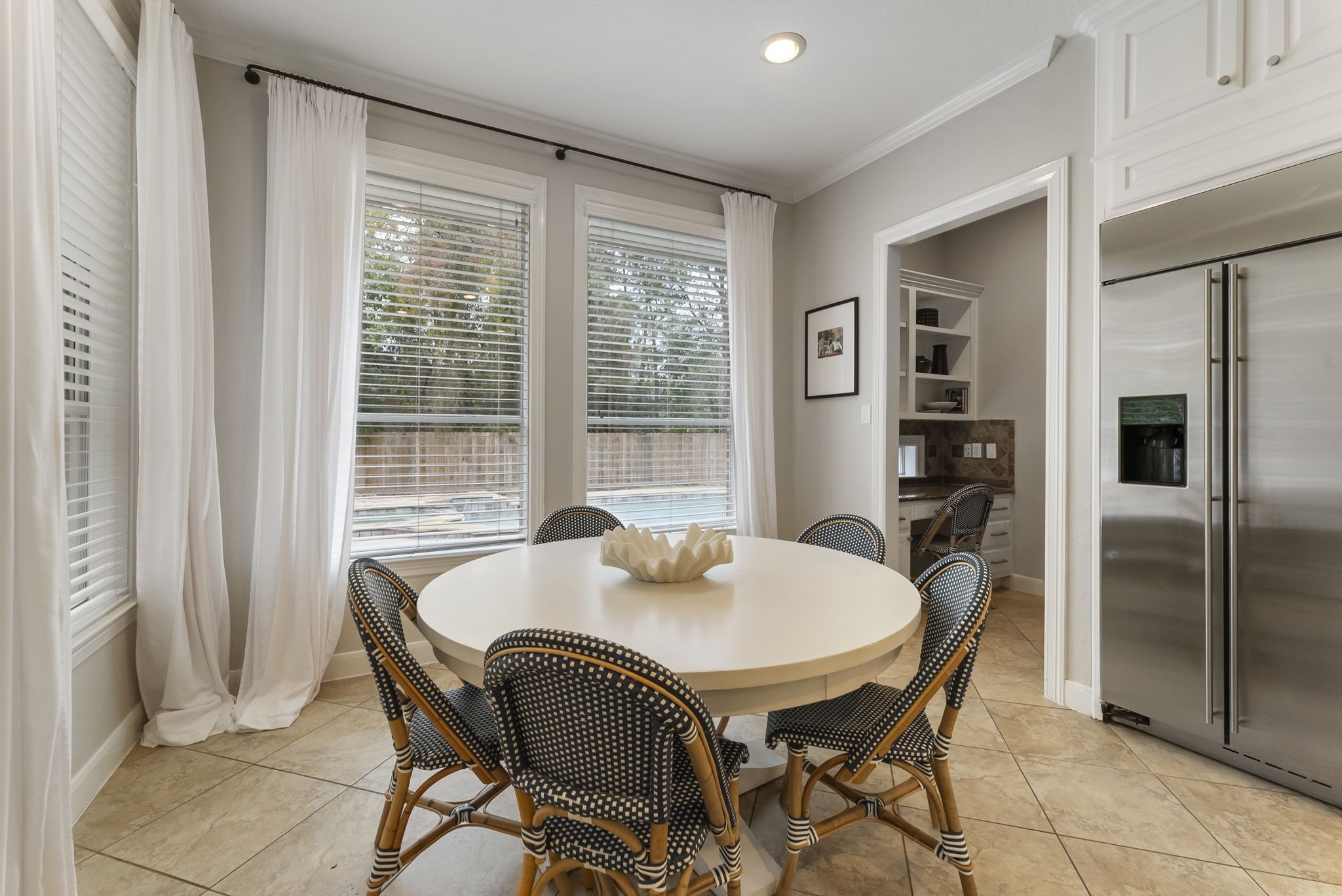 6 Lagato Place Spring, TX 77382 - Photo 16 of 42 A cozy breakfast space sits just off the kitchen, framed by large windows with backyard views. Perfect for morning coffee, casual dining, or game nights. Leads to the laundry room, built-in desk space, and 2nd staircase.