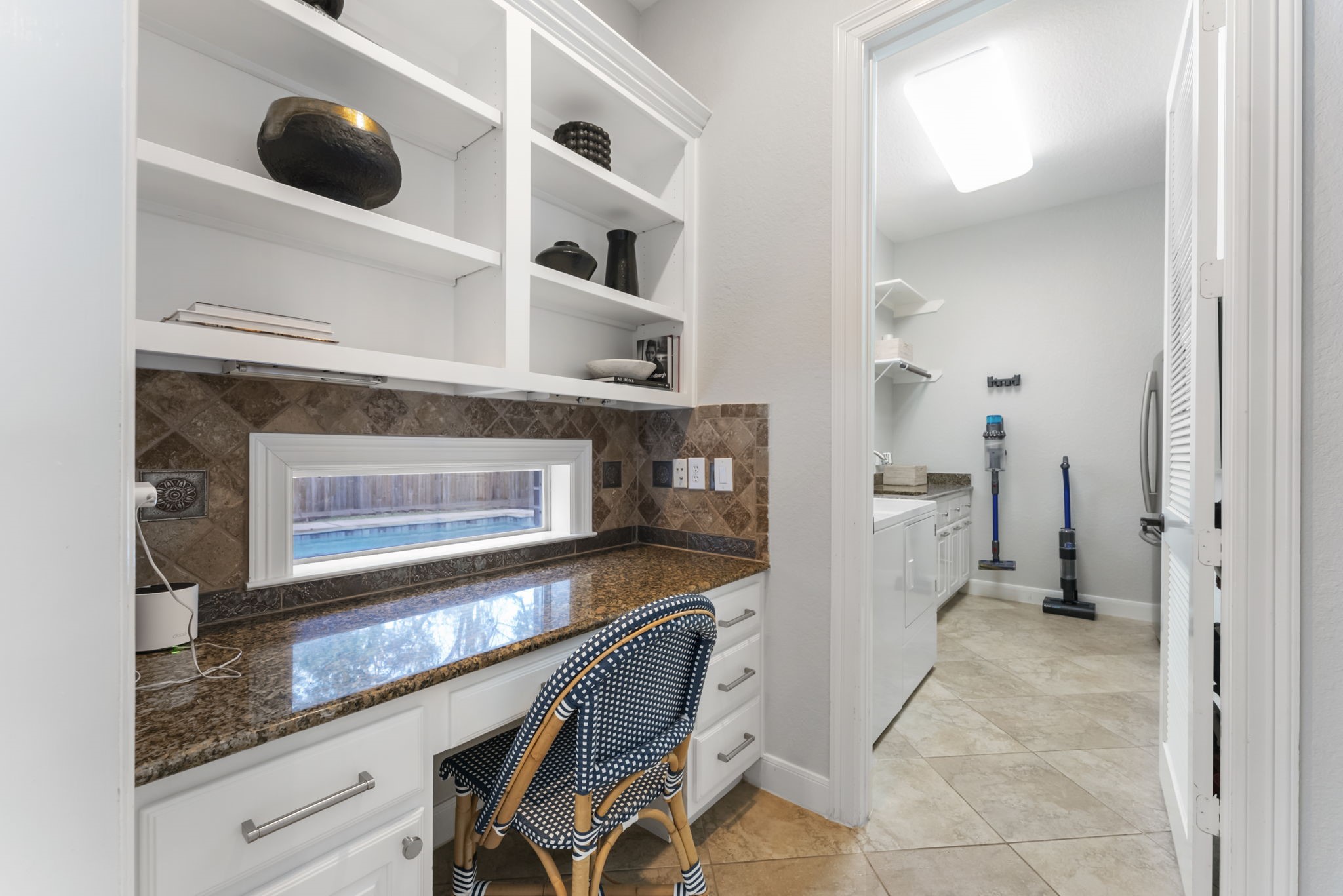 6 Lagato Place Spring, TX 77382 - Photo 17 of 42 A thoughtfully designed built-in workspace features granite counters, open shelving, and a window overlooking the backyard. Ideal for working from home, homework stations, or household organization.