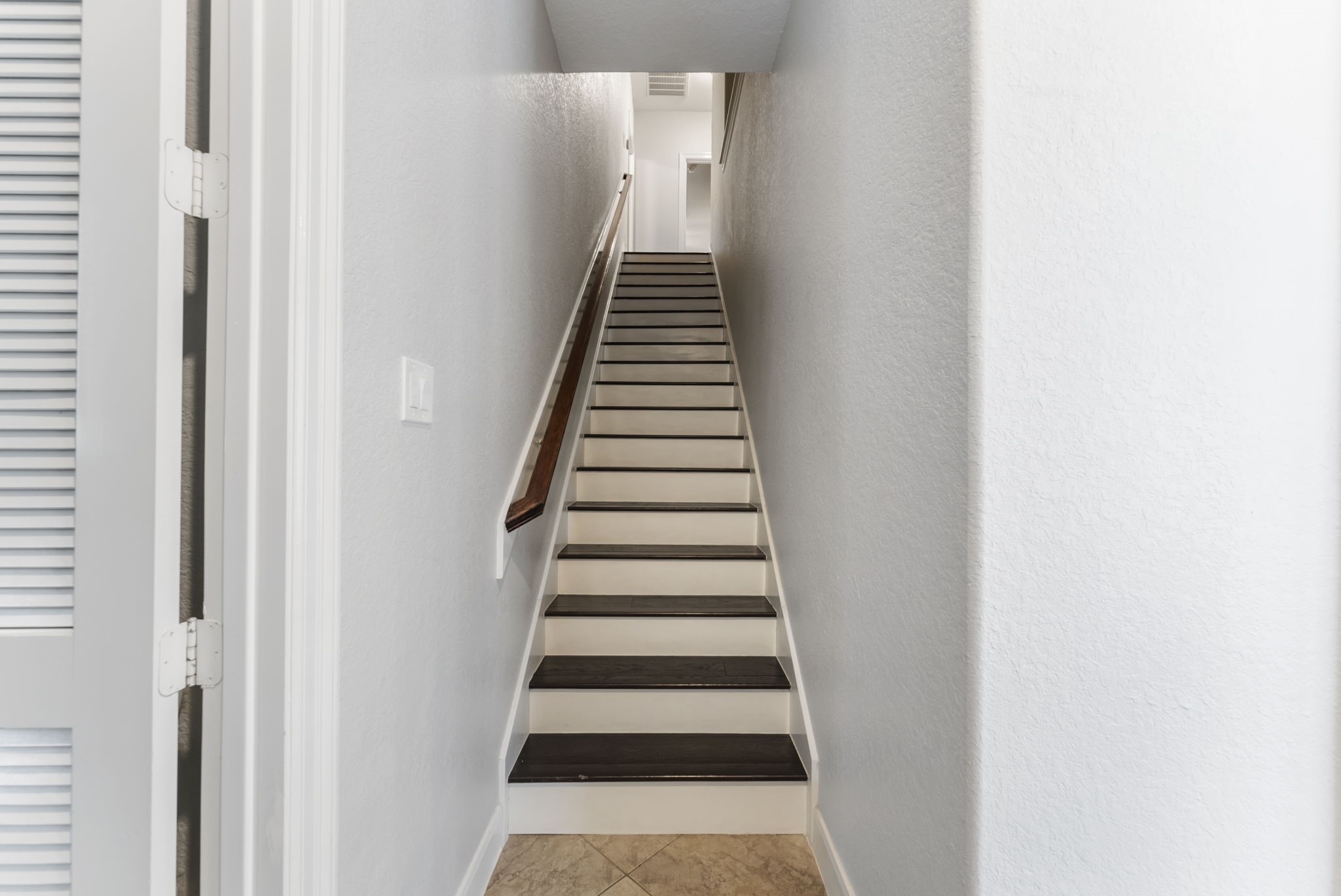6 Lagato Place Spring, TX 77382 - Photo 18 of 42 A clean-lined staircase leads to the upper level, offering a quiet transition between floors. Neutral tones and wood accents maintain continuity throughout the home.
