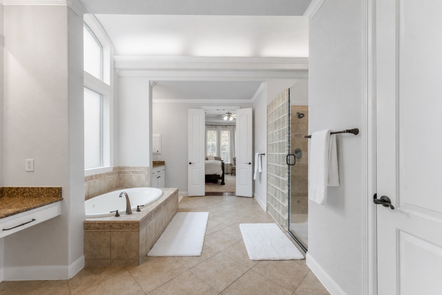 6 Lagato Place Spring, TX 77382 - Photo 22 of 42 The primary bath offers a spa-like layout with soaking tub, glass-enclosed shower, and generous counter space. A wide entry and natural light create an open, relaxing atmosphere.