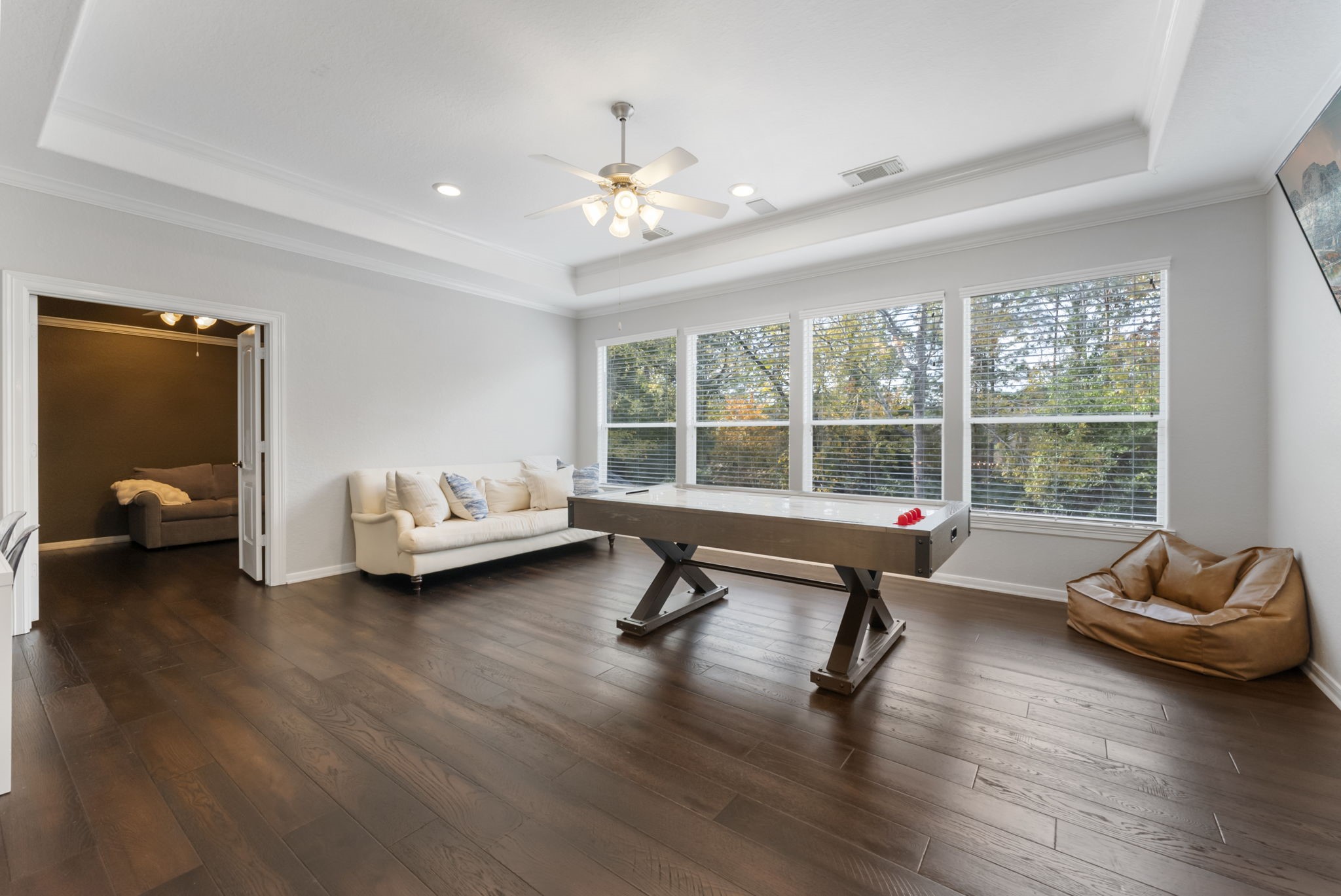 6 Lagato Place Spring, TX 77382 - Photo 23 of 42 A spacious upstairs game room offers flexible living space with rich hardwood floors and a tray ceiling with recessed lighting. Large windows overlook the treetops, filling the room with natural light. Leads to the Media Room.