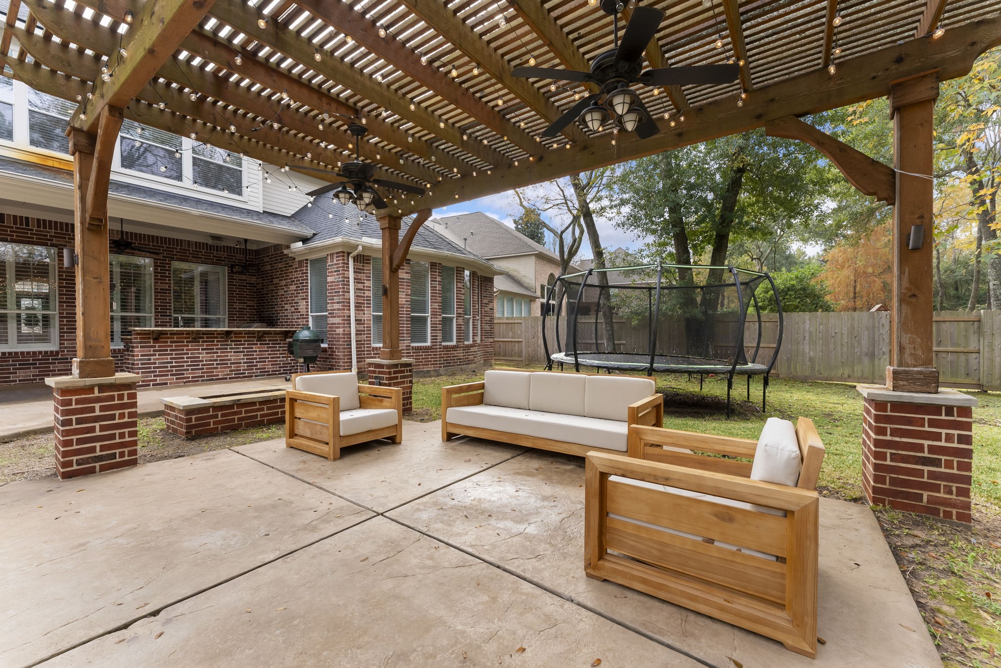 6 Lagato Place Spring, TX 77382 - Photo 36 of 42 Comfortable outdoor seating beneath the pergola offers a cozy spot for conversation and entertaining. The layout flows easily between pool, spa, and outdoor kitchen.