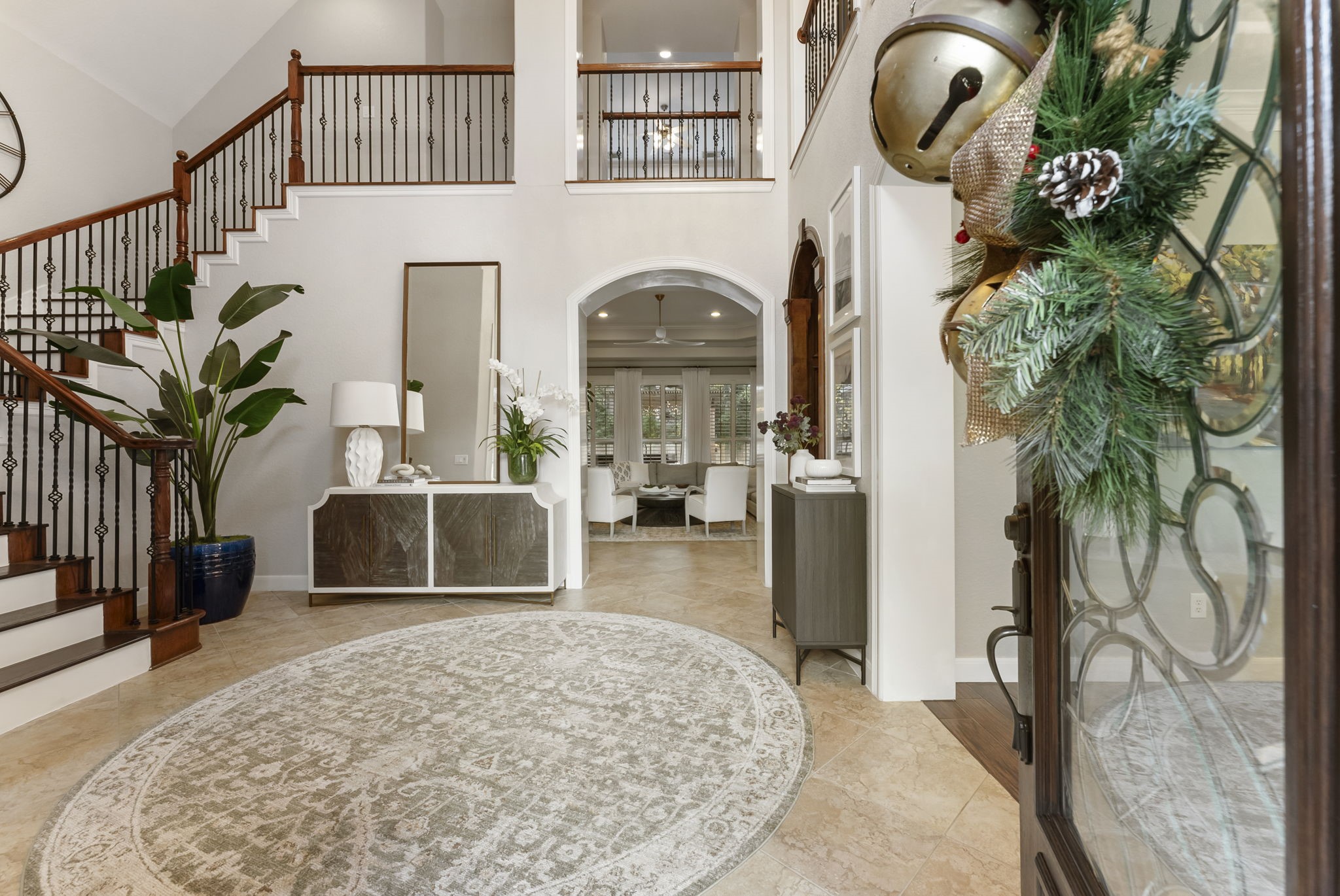 6 Lagato Place Spring, TX 77382 - Photo 4 of 42 From the front door, the home opens into a beautifully layered view of architectural arches, elevated ceilings, and curated finishes. The layout offers a sense of openness while still defining each space, ideal for both everyday living and entertaining. Upstairs overlooks add visual interest and enhance the home’s connected design.