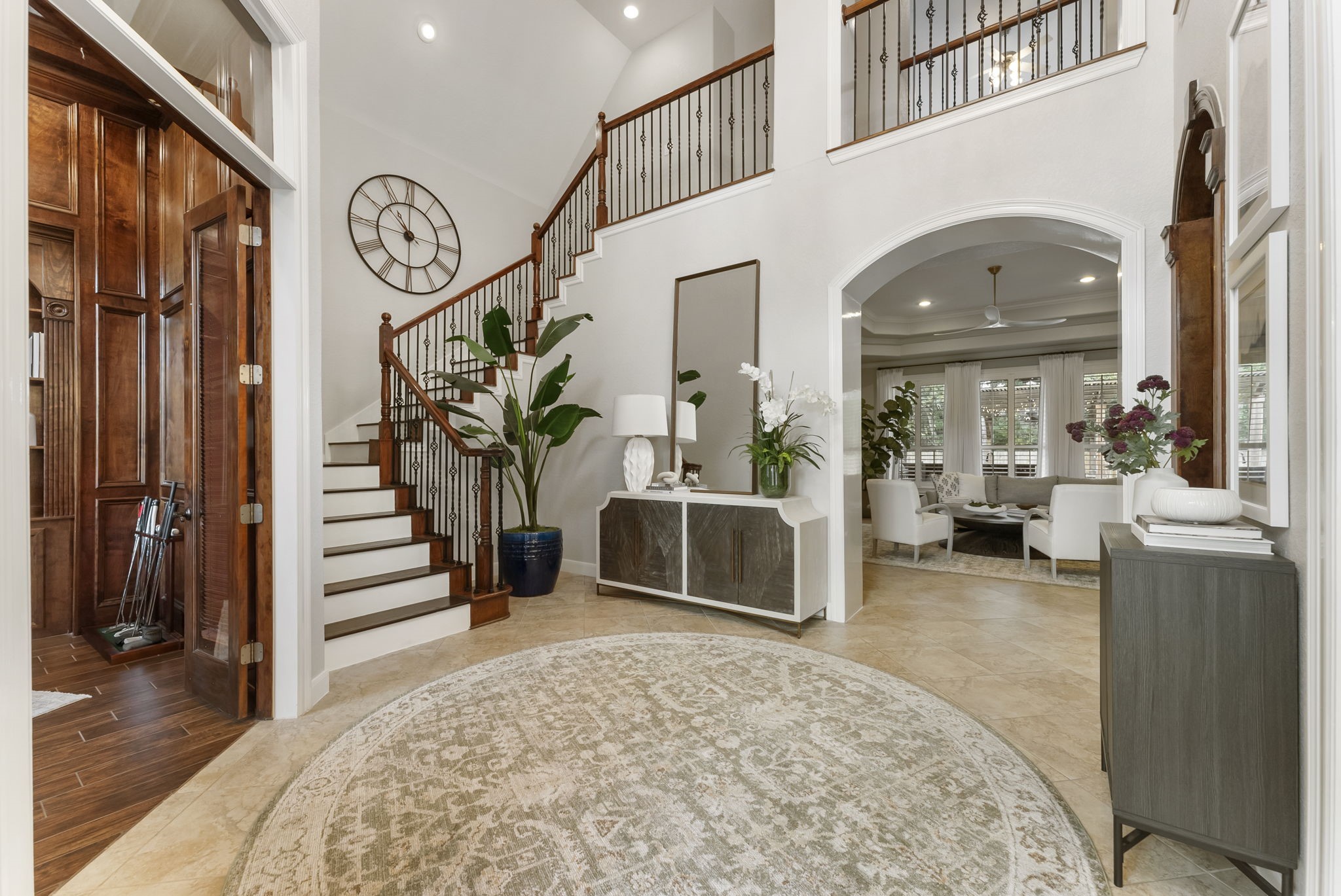 6 Lagato Place Spring, TX 77382 - Photo 5 of 42 A grand two-story foyer creates a striking first impression with a sweeping staircase, iron balusters, and warm wood accents. Natural light, arched openings, and thoughtfully styled spaces set the tone for an inviting yet refined home. This entry seamlessly connects to the main living areas and perfect for welcoming guests.