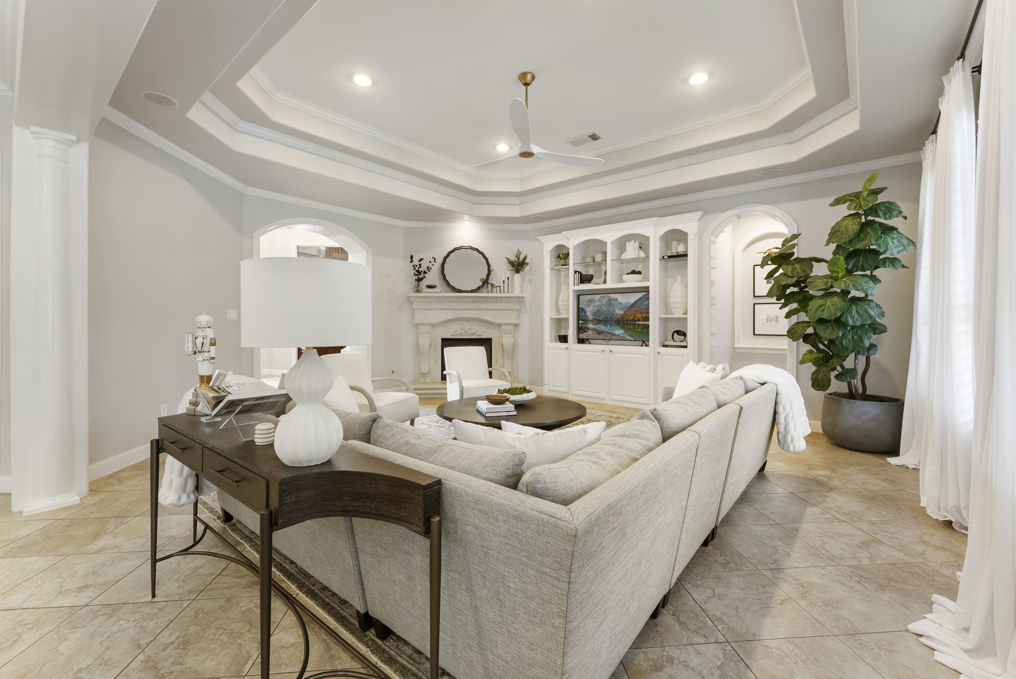 6 Lagato Place Spring, TX 77382 - Photo 10 of 42 A sculpted fireplace serves as a focal point while maintaining an open connection to surrounding spaces. The layout supports conversation, entertaining, and relaxed evenings at home.