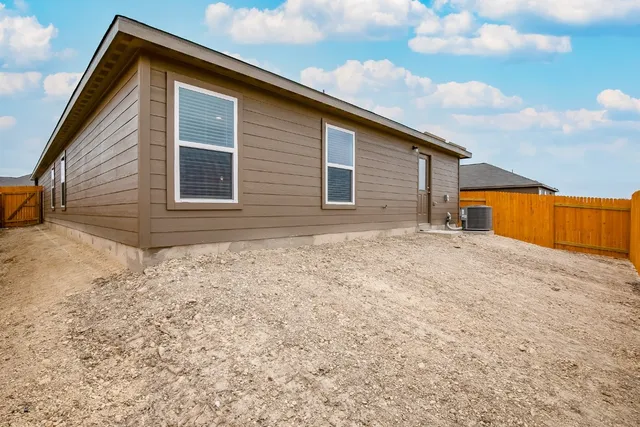 a backyard of a house with wooden fence