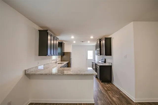 a kitchen with stainless steel appliances granite countertop a sink and a refrigerator