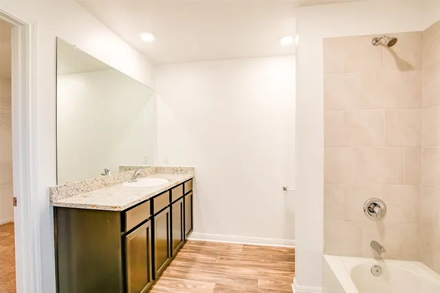 a bathroom with a tub sink and mirror