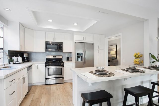 a kitchen with stainless steel appliances kitchen island granite countertop a sink stove and refrigerator