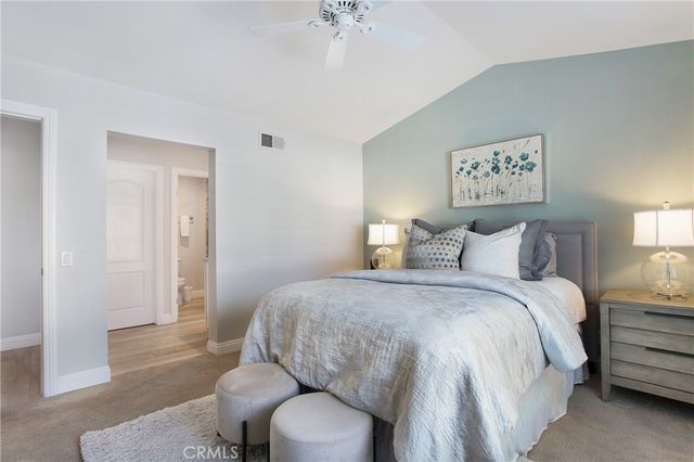 a spacious bedroom with a bed and a chandelier