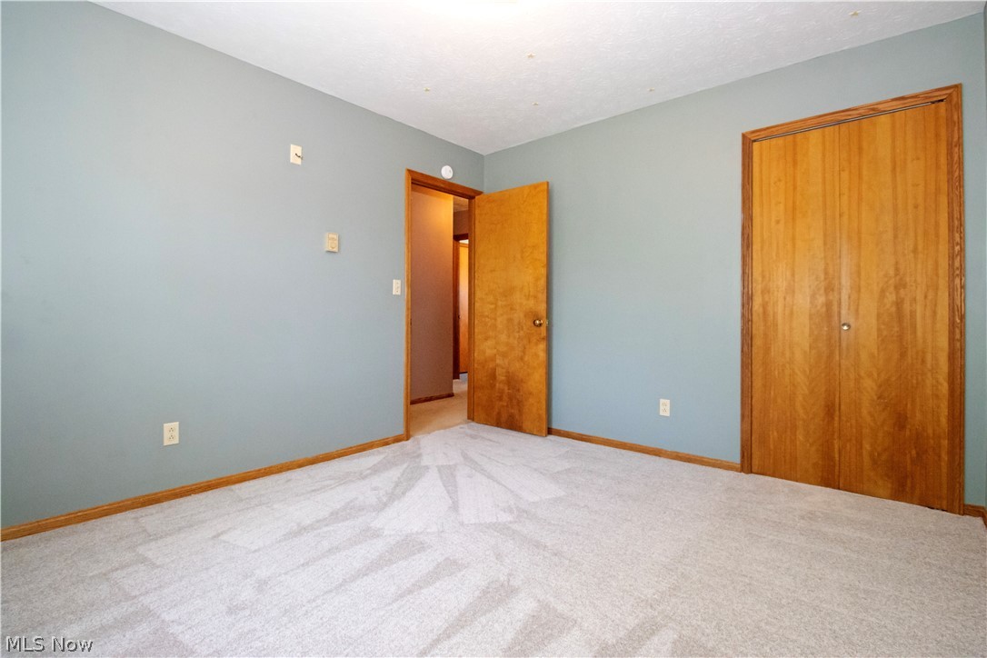 9360 Zimmerman Road Wooster, OH 44691 - Photo 13 of 33 Unfurnished bedroom with light colored carpet and a closet