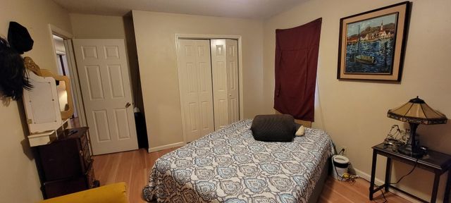 a bedroom with a bed and wooden floor