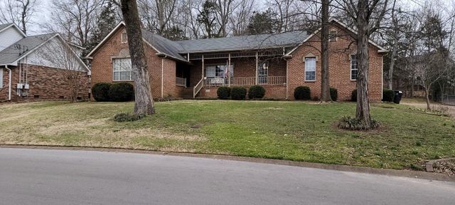 a view of a house with backyard and tree