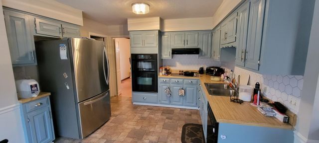 a kitchen with stainless steel appliances granite countertop a refrigerator and a stove