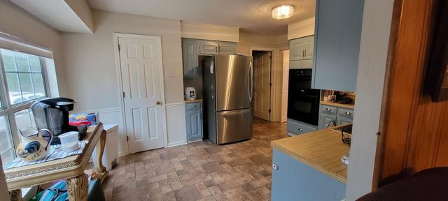 a view of a kitchen with refrigerator and workspace