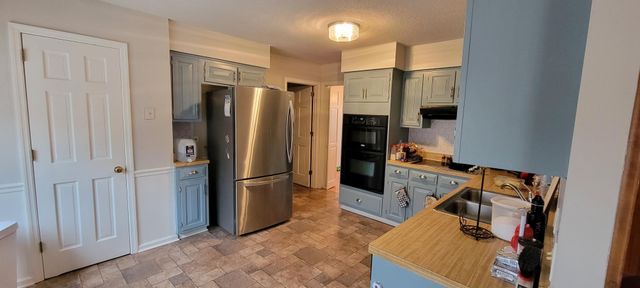 a kitchen with stainless steel appliances granite countertop a refrigerator and a sink