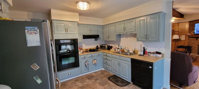 a kitchen with stainless steel appliances granite countertop a refrigerator sink and stove