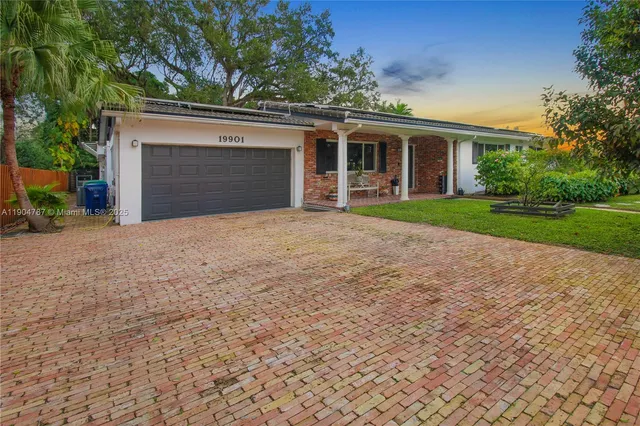 a dining room with wooden floor a chandelier a glass table and chairs