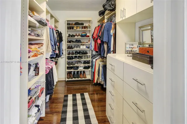 a kitchen with stainless steel appliances granite countertop a stove top oven a sink a dining table and chairs with wooden floor