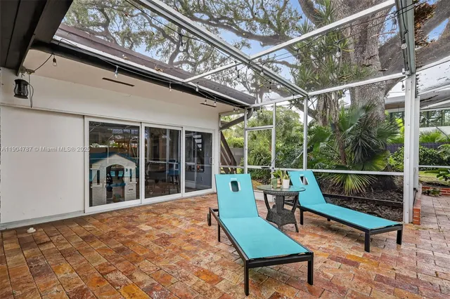 a view of a patio with table and chairs next to a yard