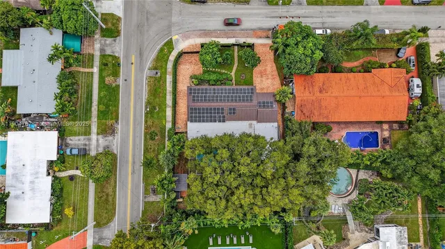 an aerial view of residential houses with outdoor space and swimming pool