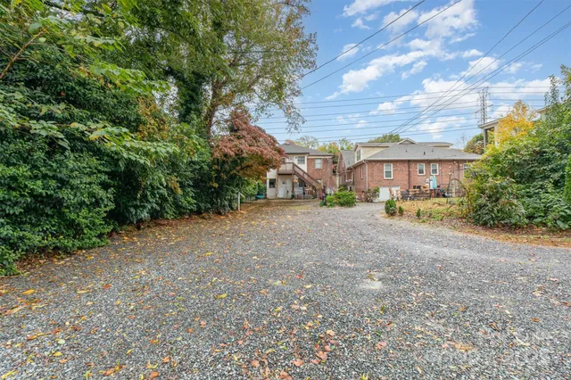a view of an house with backyard and a tree