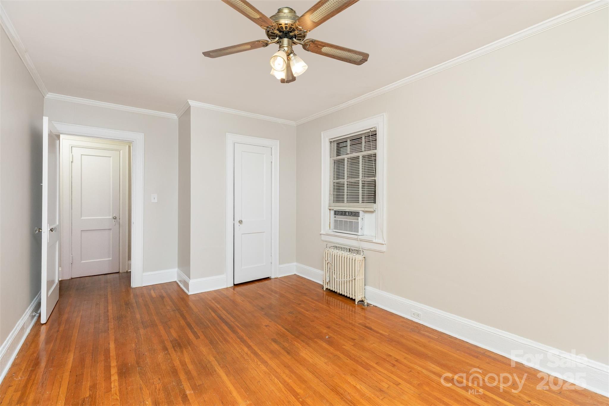 1412 Kenilworth Avenue Charlotte, NC 28203 - Photo 9 of 25 a view of a bedroom with wooden floor and ceiling fan