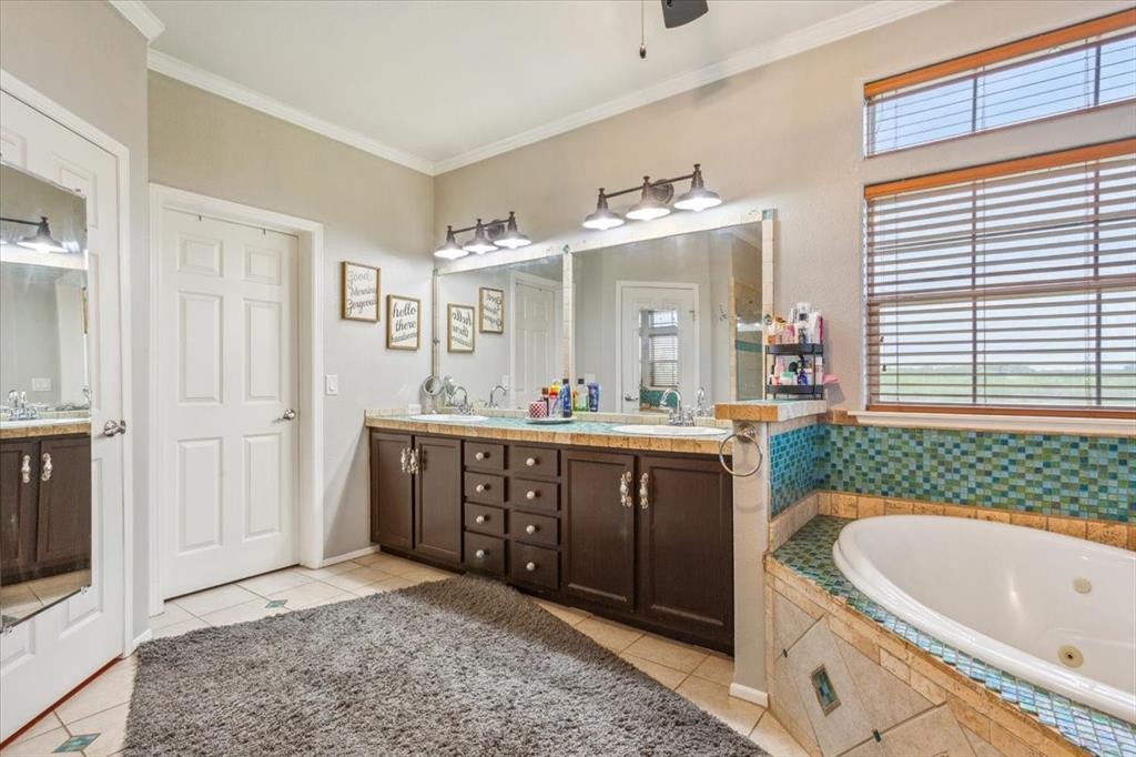 3356 Kattner Road Riesel, TX 76682 - Photo 18 of 40 a spacious bathroom with a granite countertop tub sink and mirror
