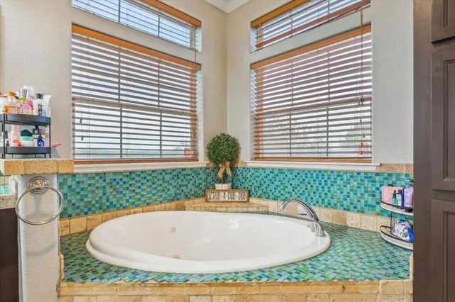 a bathroom with a granite countertop sink a mirror a shower and a bathtub