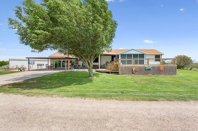 a front view of a house with a garden and trees